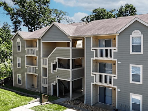 A grey apartment building with balconies and doors.