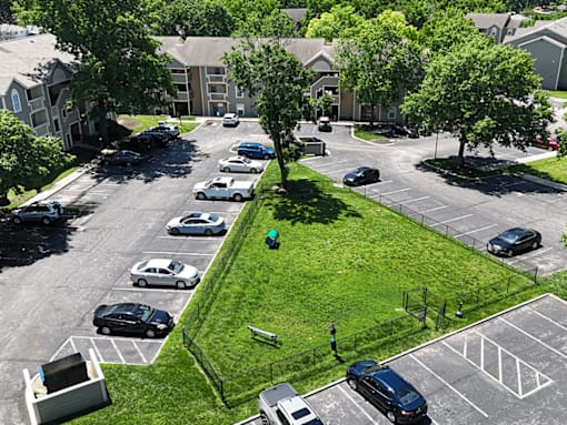 A parking lot with cars and a green lawn.