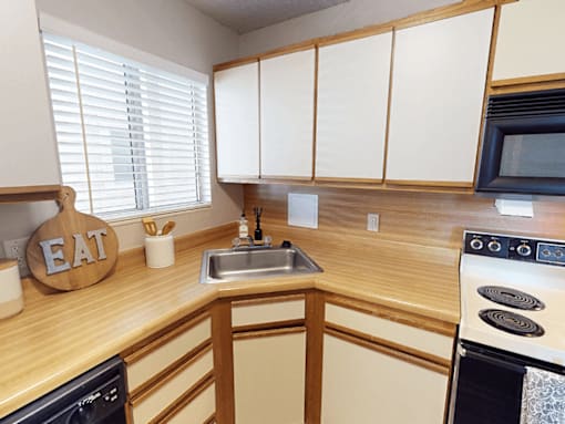 A kitchen with wooden cabinets and a sign that says EAT