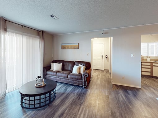 A living room with a brown couch and a coffee table.