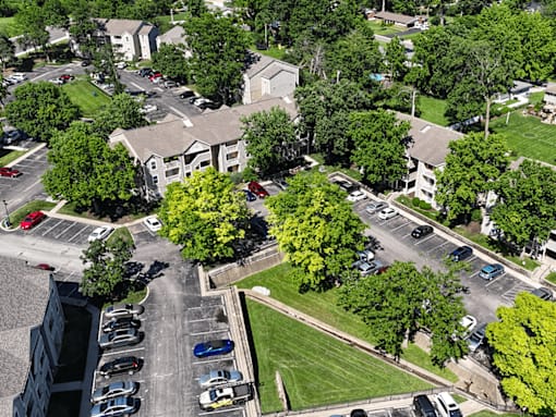 A parking lot with cars and apartment buildings in the background.