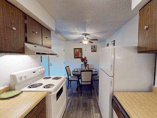 A kitchen with a stove, table and chairs.