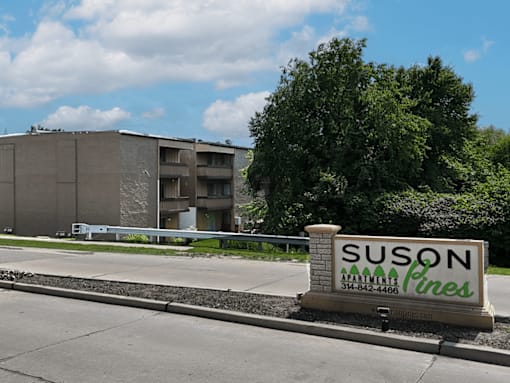 A building with a sign that says  Suson Pines Apartments