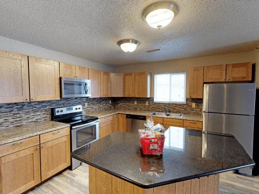 apartment kitchen with a granite counter top and wooden cabinets