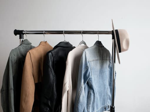 a rack of clothes with a hat on top of it