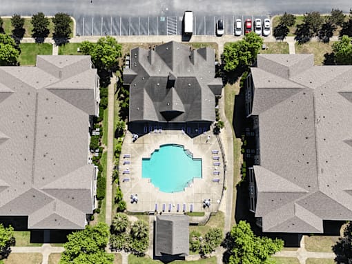 A bird's eye view of a housing complex with a pool in the middle.