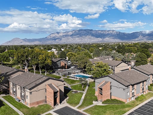 A view of apartment buildings with a mountain range in the background.