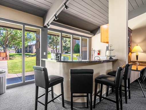 A bar area with four black chairs and a counter.
