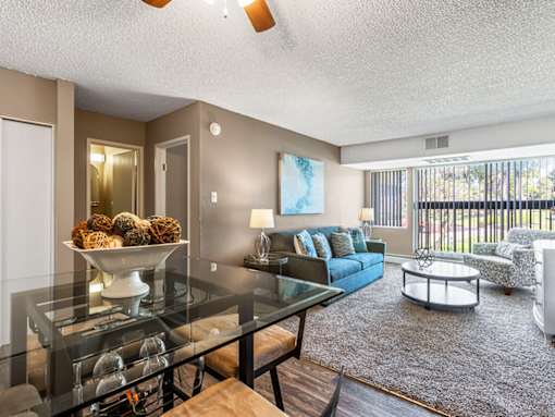 A living room with a glass table and a sofa.