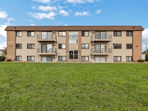 a large apartment building with green grass in front of it