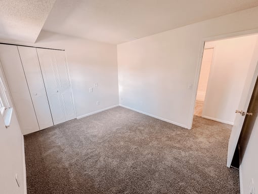an empty bedroom with white walls and a closet