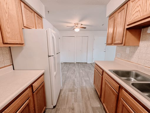 a kitchen with wooden style cabinets and a refrigerator
