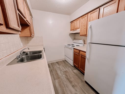 a kitchen with white appliances and wooden cabinets