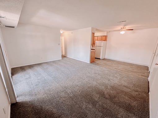 apartment living room with a kitchen and dining area in the background