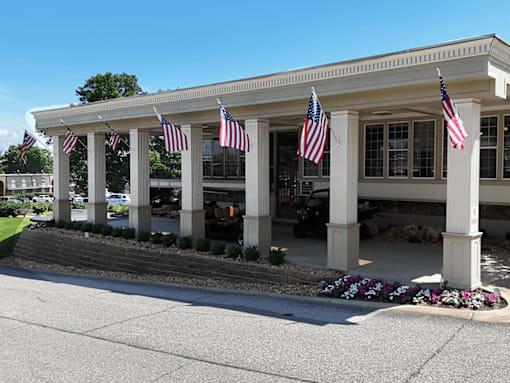 A building with columns and flags hanging from the roof.