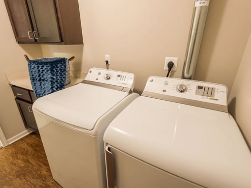 a washer and dryer in a room with a sink and cabinets