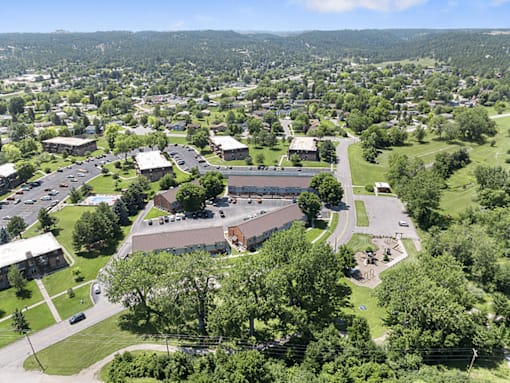 A large building complex with a parking lot in front of it.