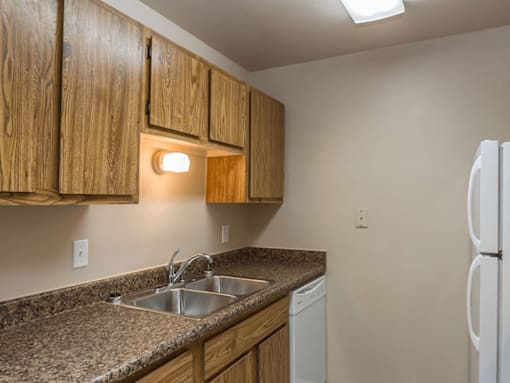 A kitchen with wooden cabinets and a granite countertop.