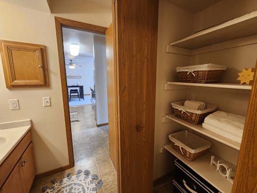 A kitchen with a pantry door open to a living room.