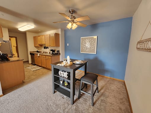 A kitchen with a dining table and chairs in the middle of the room.