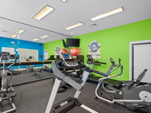 a gym with various exercise equipment and mirrors