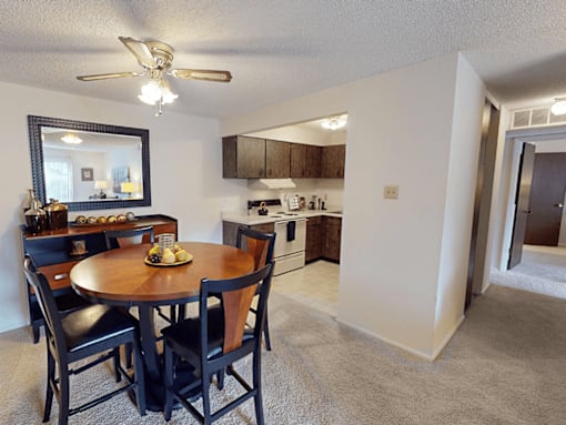 A kitchen with a dining table and chairs.