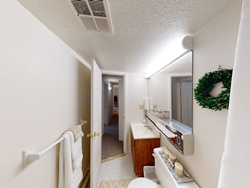 A bathroom with a white towel hanging on the towel rack.