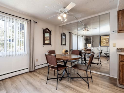 A dining room with a table and chairs.