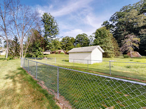 A chain link fence runs along a grassy area.