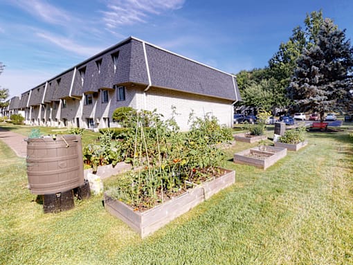 A building with a grey roof and a garden in front.