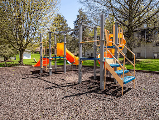 A playground with a slide, swings, and a climbing frame.
