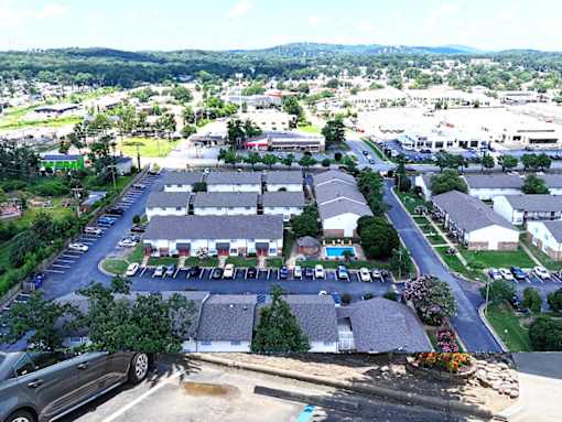 A parking lot is in the foreground of a residential area.