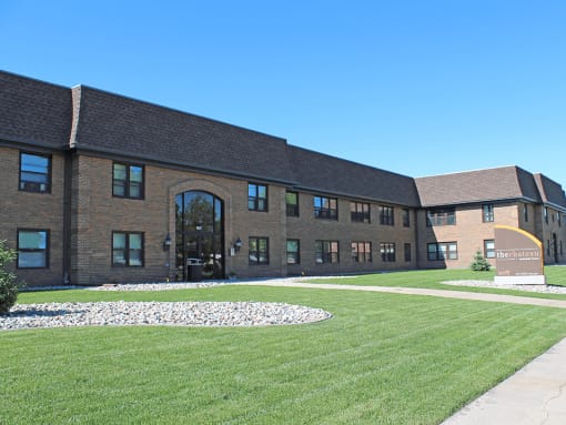 a large brick building with a grassy area in front of it