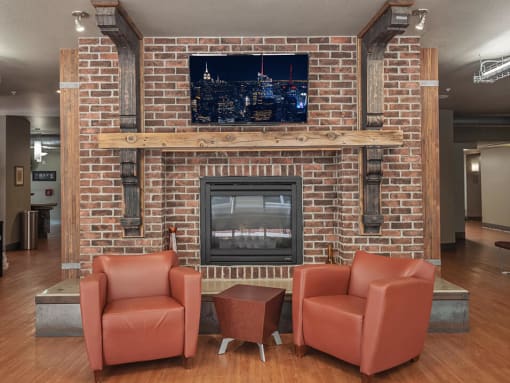 a rec room with a fireplace and chairs