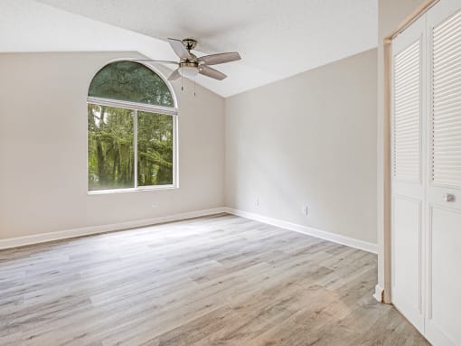 Large bedroom with window and hard wood flooring