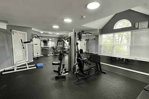 A black and white photo of a gym with various exercise equipment.
