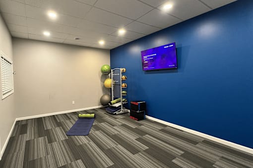 A room with a blue wall and a television mounted on it.