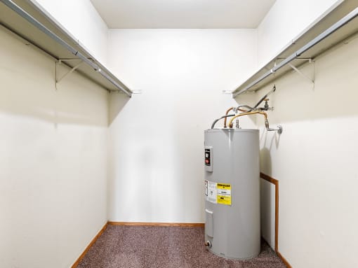 a room with a water heater and a radiator in the corner