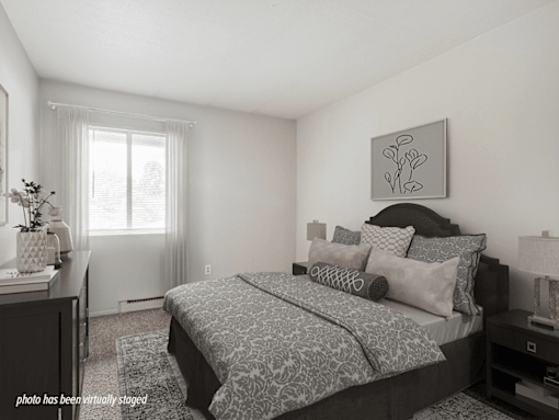 A bedroom with a large bed and a painting on the wall.