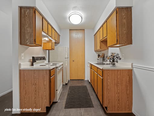A kitchen with wooden cabinets and a white stove top oven.