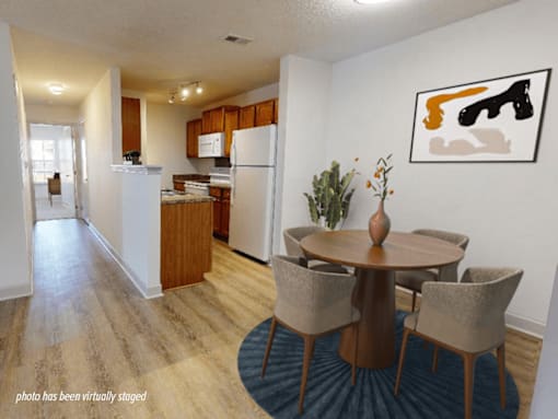 A kitchen with a dining table and chairs.