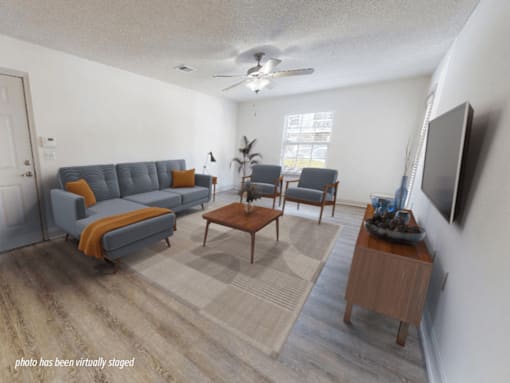 A living room with a grey couch, a wooden coffee table, and a television.