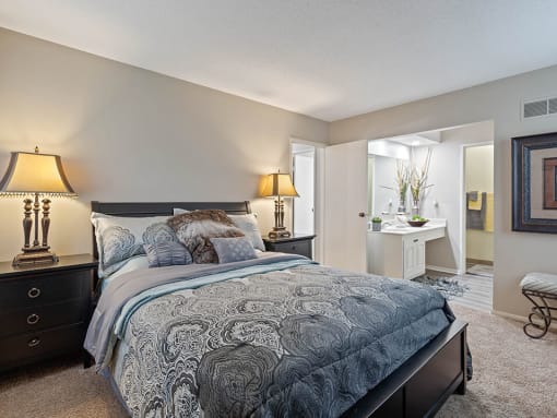 a bedroom with a bed and a bathroom with a sink