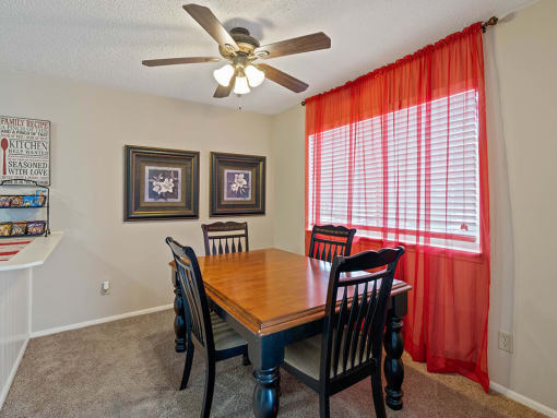 a dining room with a table and chairs and a ceiling fan