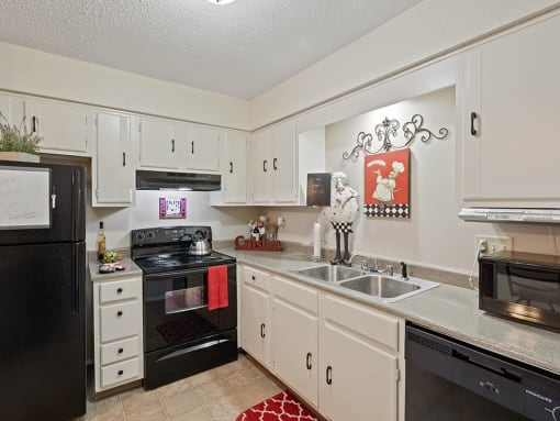 a kitchen with black appliances and white cabinets
