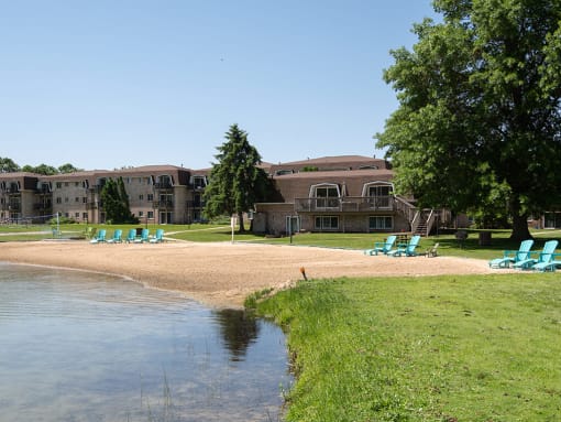a beach with chairs and a body of water in front of a building