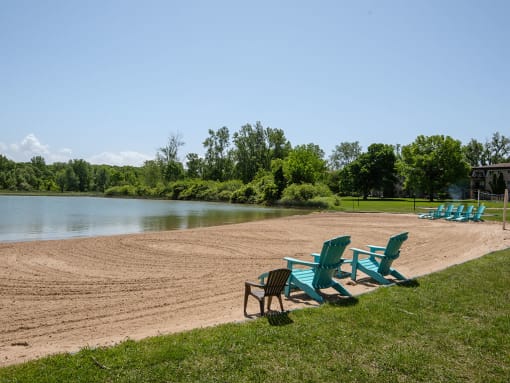 a group of chairs sitting on a beach next to a lake