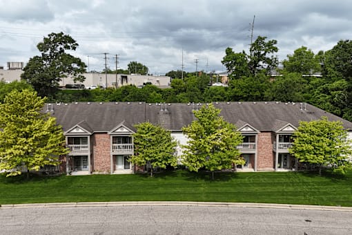 A row of houses with trees in front of them.