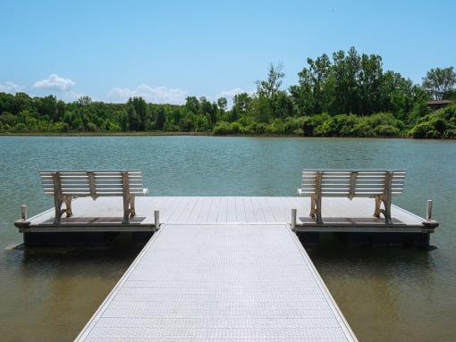 two benches on a dock on the water