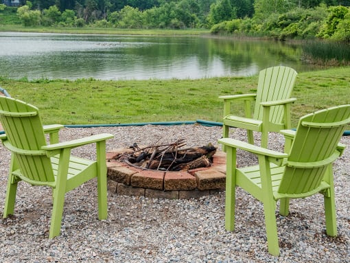 a group of green chairs sitting around a fire pit